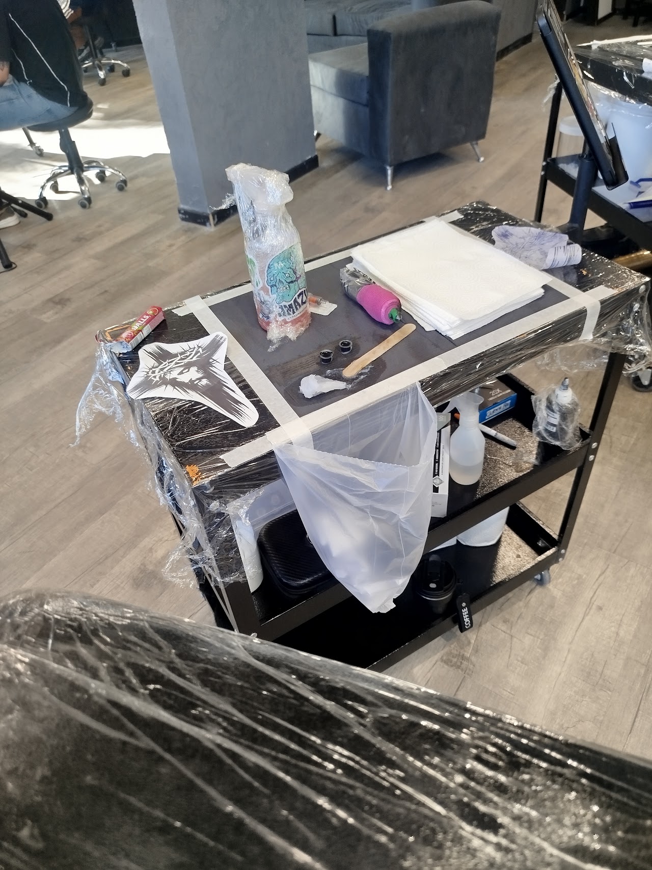 Estación de trabajo del estudio Mamba Tattoo lista para sesión, con elementos descartables y de bioseguridad